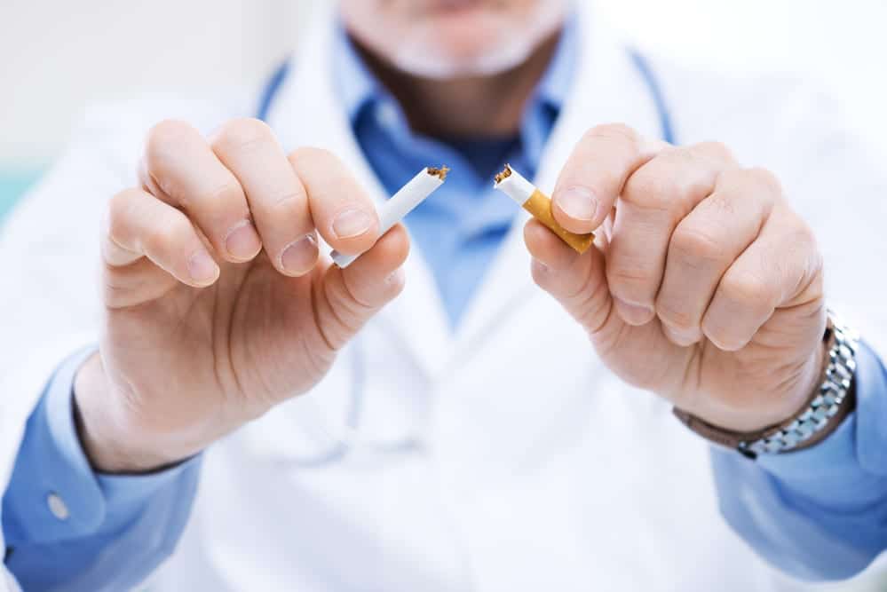 Close-up-of-doctors-hands-breaking-a-cigarette-in-half