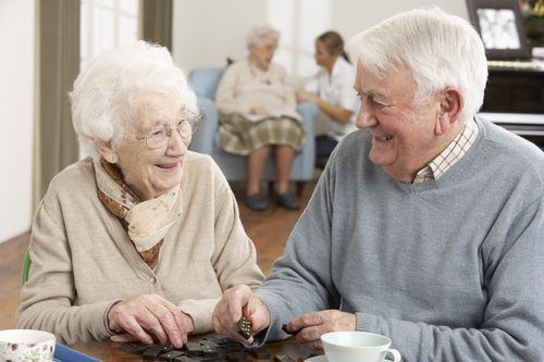 senior couple smiling playing dominos