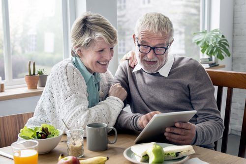Senior couple looking at tablet, smiling
