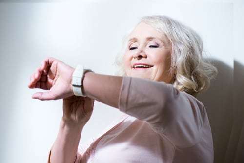 senior woman looking at smart technology watch on her wrist