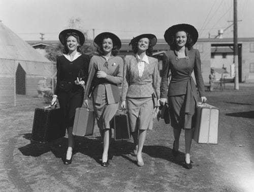 vintage photo of women in traveling suits with luggage