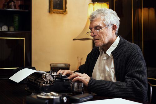 senior man writing on typewriter