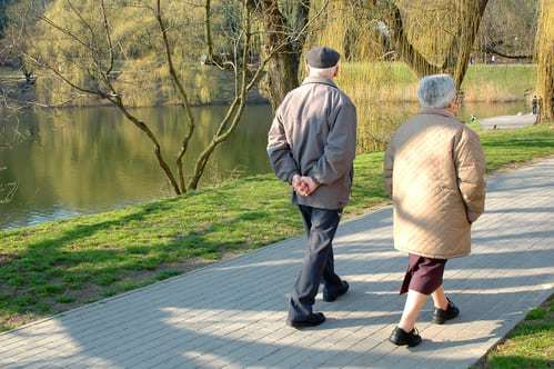 two seniors walking in a park
