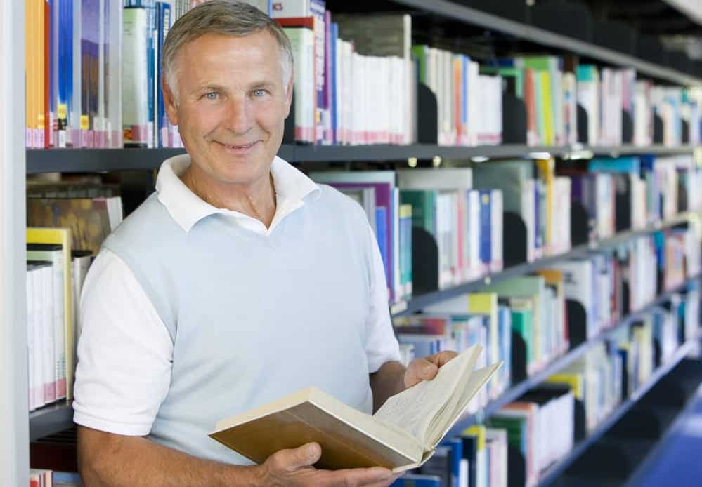 Senior man reading in a librar