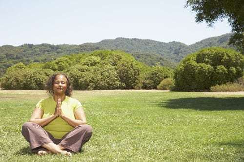 African American woman enjoying the benefits of meditation for seniors outside