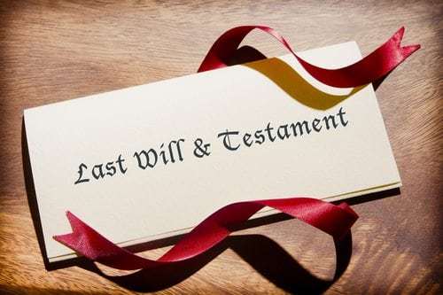 last will and testament with red ribbon on table