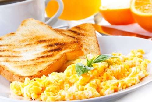 breakfast with scrambled eggs, toasts, juice and coffee