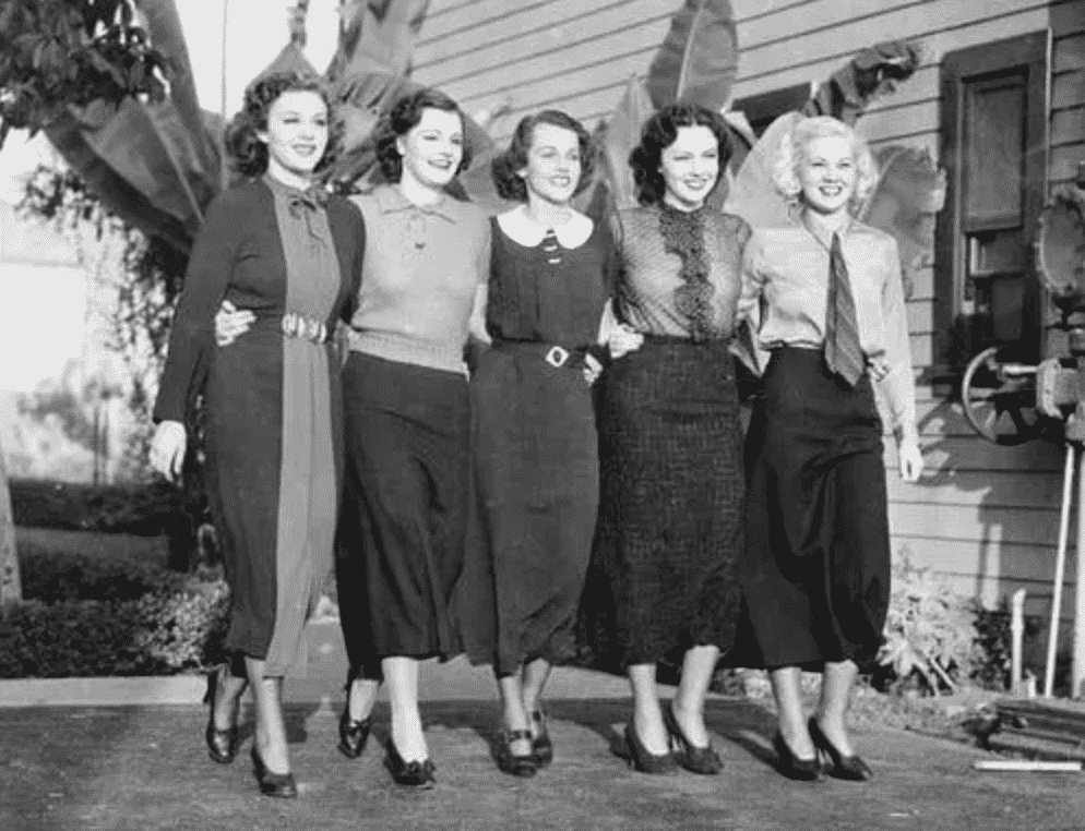 Five women posing with their arms around each other. Black and white photo from the 1940's.