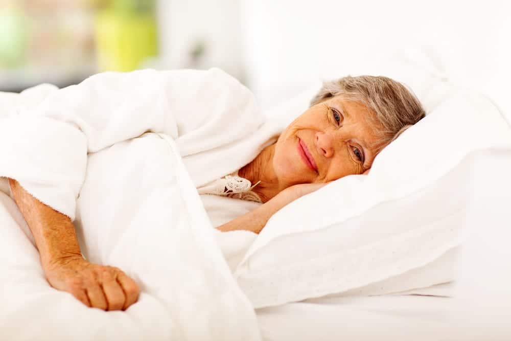 Senior-woman-lying-in-bed-smiling