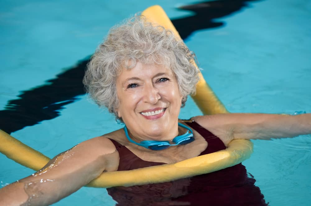 Smiling-senior-woman-swimming-in-pool