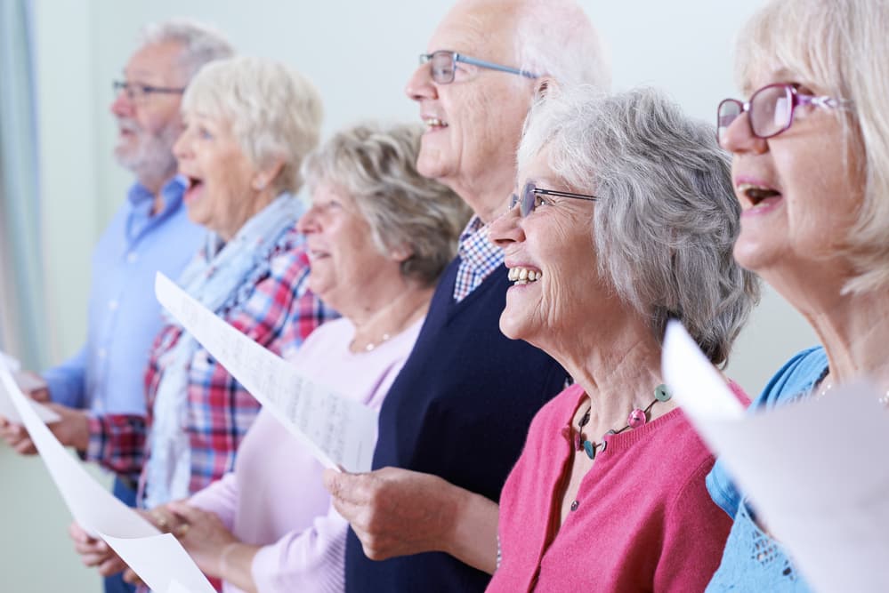 Smiling seniors singing together in choir