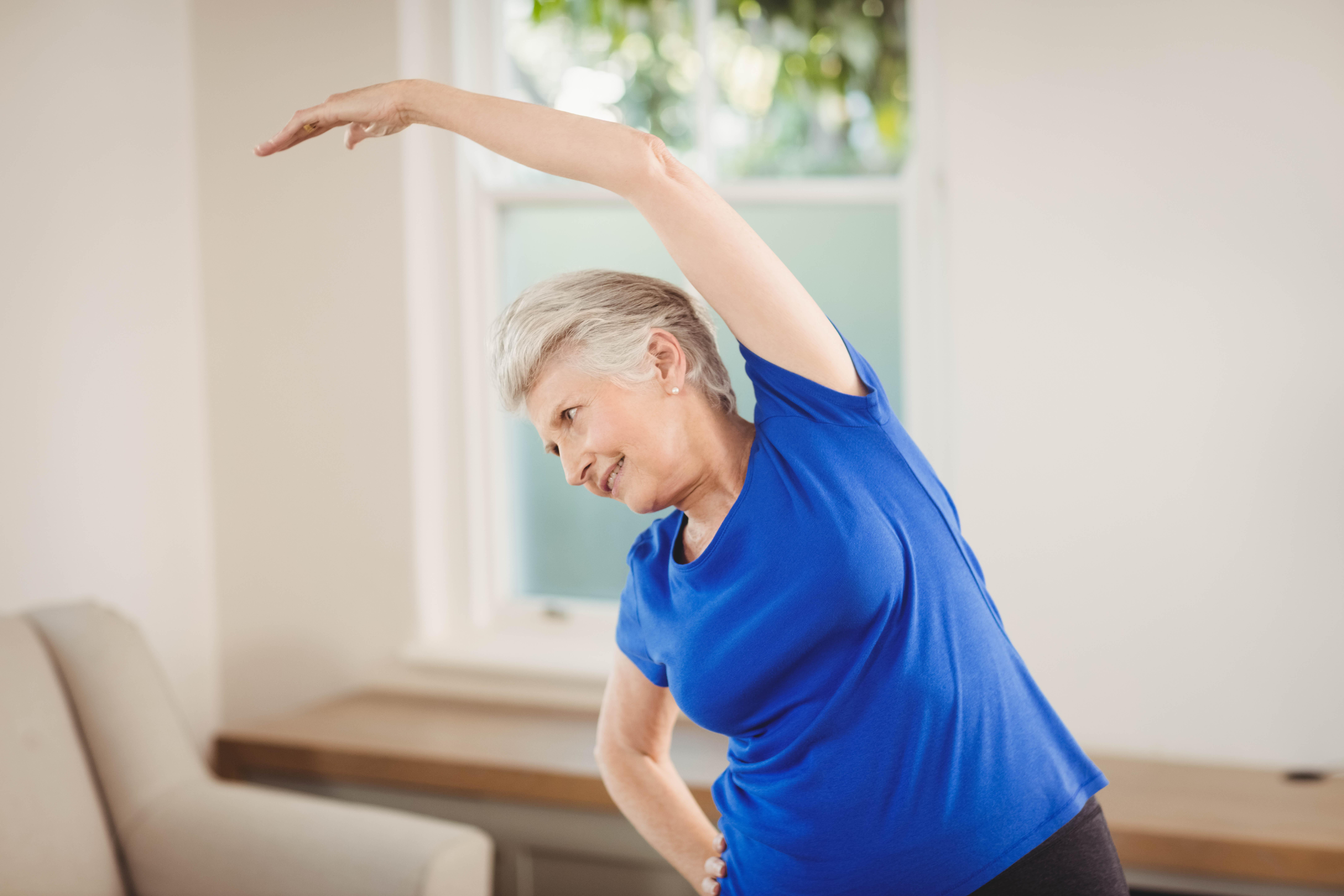 https://www.hearthsideseniorliving.com/wp-content/uploads/2024/02/Senior-woman-stretching-at-home.jpg