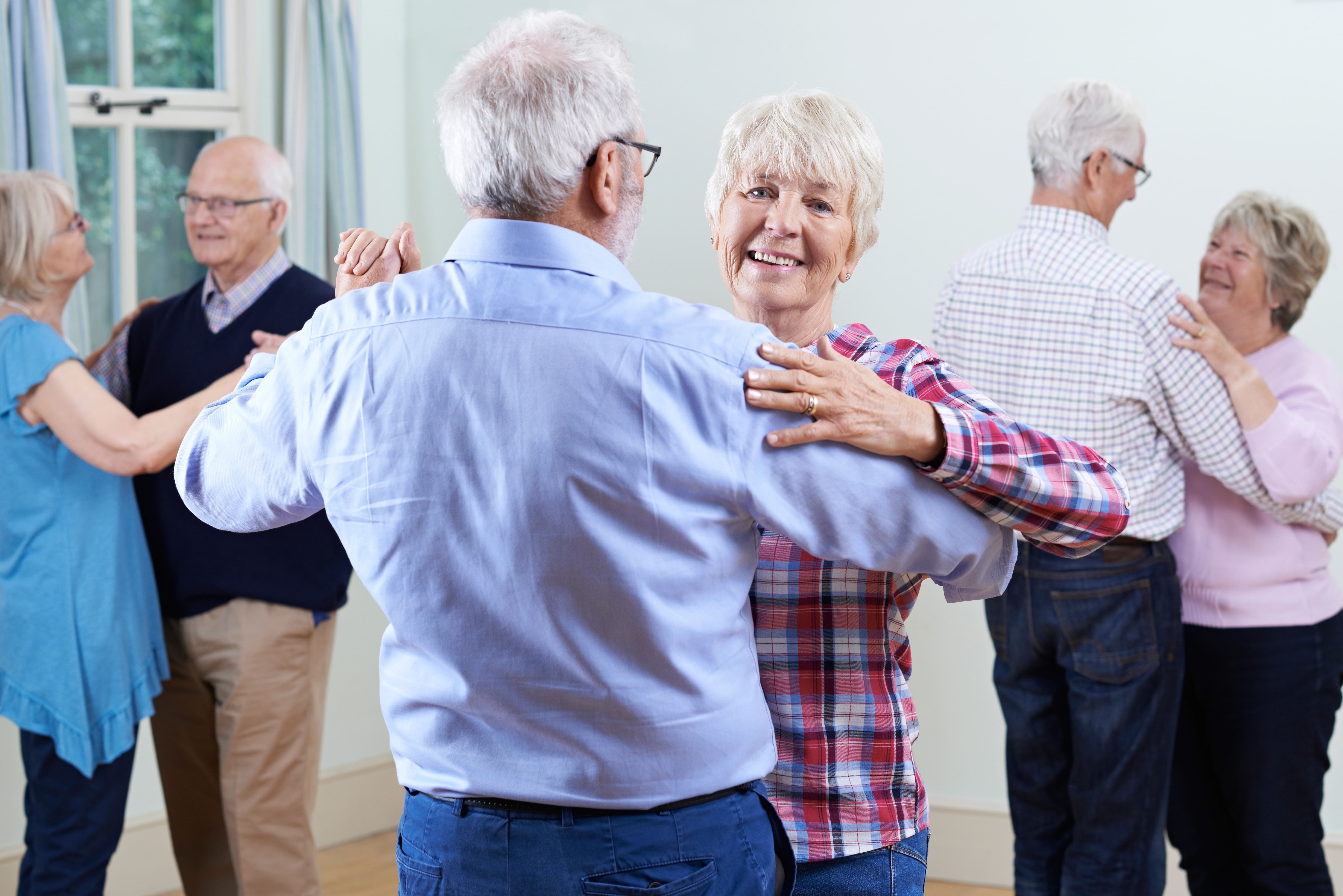 Senior couple dancing among other seniors